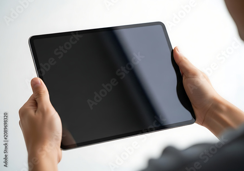 Person holding black tablet device