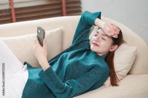 Schilderij op canvas Young woman experiencing digital eye strain and exhaustion from prolonged smartp