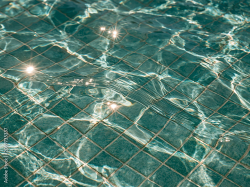 Sunlit turquoise pool mosaic tiles, sparkling water macro