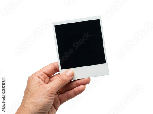 Person hand holding an empty vintage instant photo frame