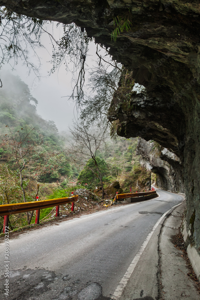 Naklejka premium Mountain road under rock tunnel in Taiwan