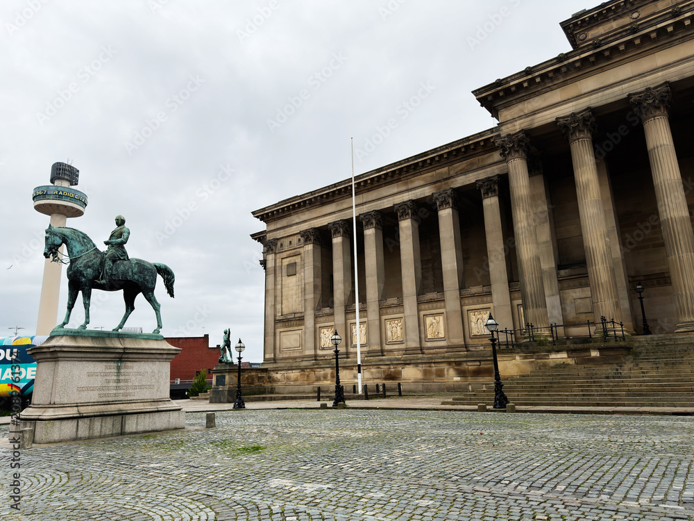 Obraz premium Neoclassical St George's Hall with equestrian statue on empty cobbled plaza under overcast sky in Liverpool, UK
