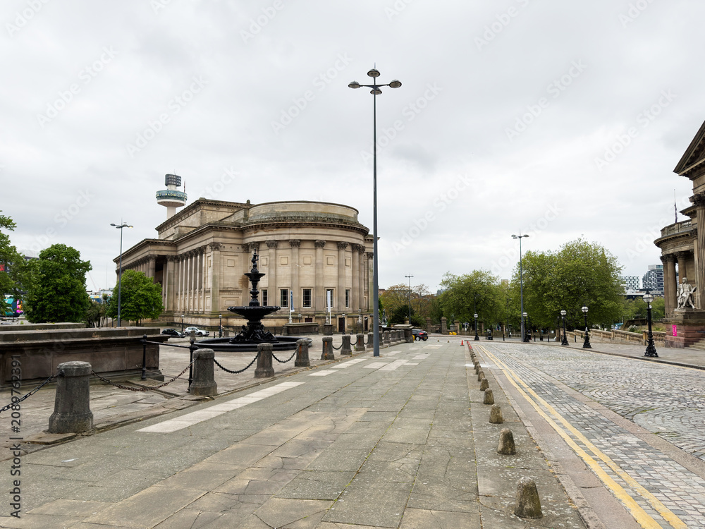 Obraz premium Historic neoclassical St Georges Hall with fountain and empty plaza in Liverpool, UK under overcast sky