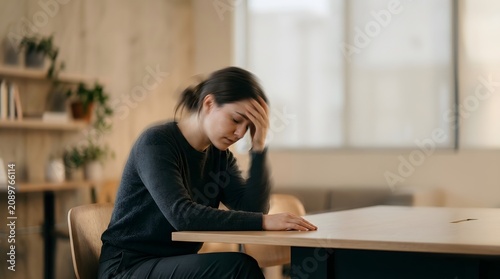 Exhausted female holding her head in despair indoors