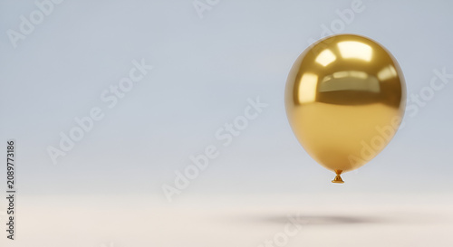 Shiny golden balloon floating with soft grey background, celebration concept