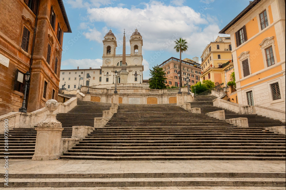 Obraz premium Piazza di Spagna - Spanish Steps - in the morning in Rome, Italy with view of the Trinità dei Monti church on a sunny day with blue sky and white clouds.&nbsp;