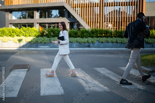 Foto Business professionals walking across street in city