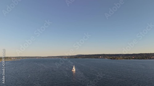Aerial Sunset View of a Lone Sailboat on Calm Lake Water