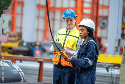 Obraz na plátně Team of industrial professionals working together to maintain machinery in a fac
