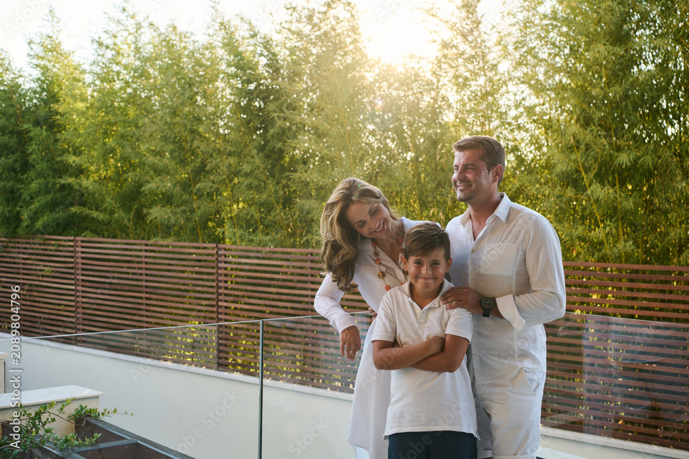Fototapeta premium Happy Family on Modern Home Balcony and Rooftop Terrace Enjoying Sunny Sea View Vacation