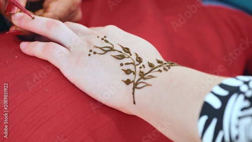 Photography Applying traditional henna body art design on hand during India Day festival in