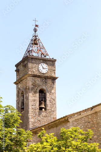 Clocher d'une église en pierre dans un village du sud avec horloge, girouette, cloche, campanile. Montclus dans le Gard, France