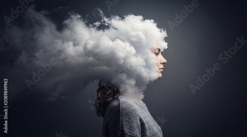 A woman's head dissolving into a cloud of smoke, symbolizing complex thoughts or mental fog.