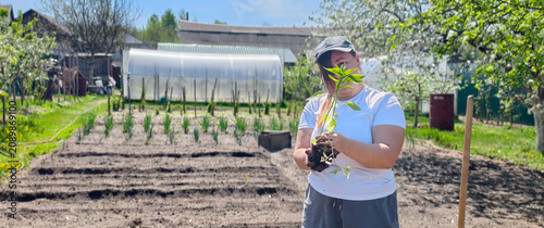фотографія Woman holding a young vegetable seedling over freshly turned garden soil, ready to transplant for an organic, homegrown harvest supporting sustainable, healthy living and growth
