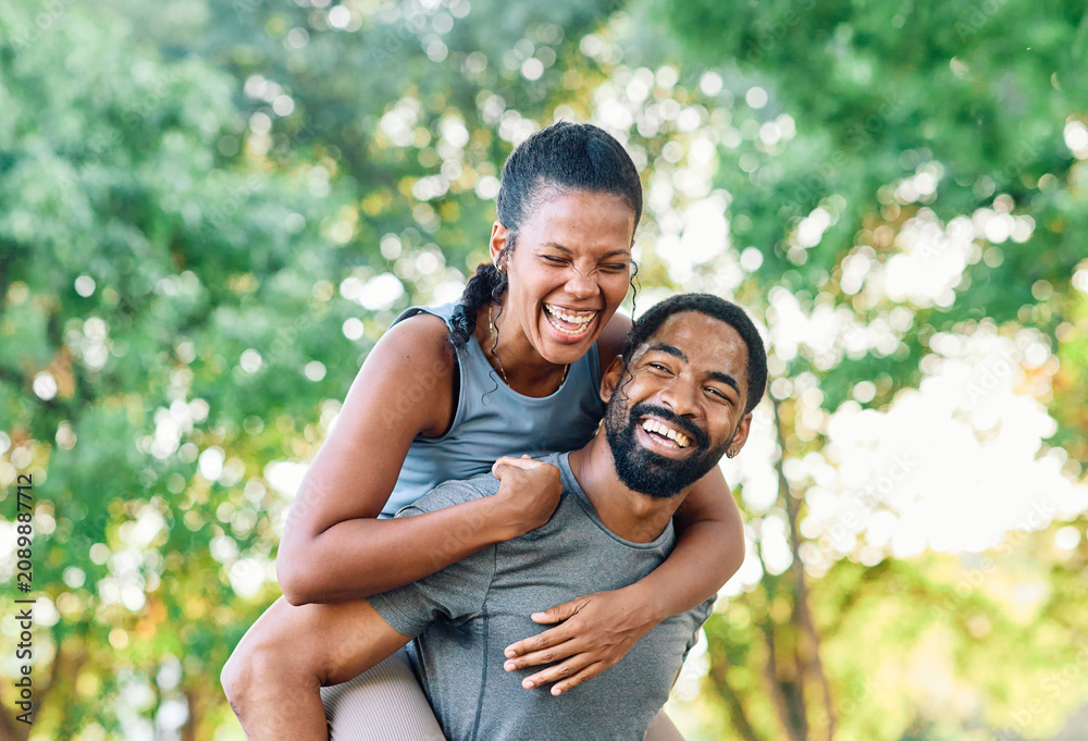 Fototapeta premium Smiling active young couple having fun together in the park, active healthy people bonding, couple happy relationship