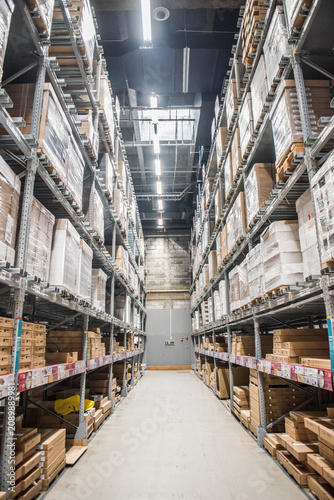 Konstfotografi Large warehouse aisle with storage racks and stacked boxes