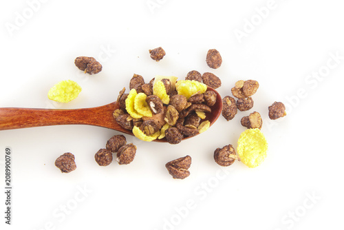 Chocolate cereal muesli with corn flakes on wooden spoon - healthy breakfast food studio photography