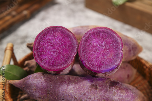 Fresh Purple Vietnamese Sweet Potatoes Cut in Half Showing Vibrant Magenta Flesh on Wooden Cutting Board
