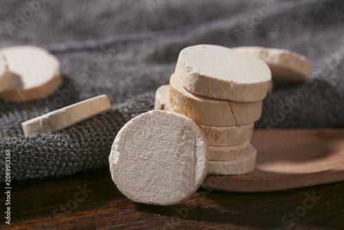 Traditional dried yam slices on wooden board with woven basket in rustic kitchen studio shot