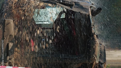Mud racing. A modified SUV, covered in mud, is sprayed with water after the race. Extreme sports concept