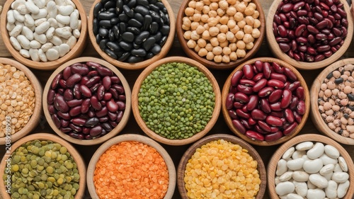 Assorted colorful dried legumes and beans in wooden bowls