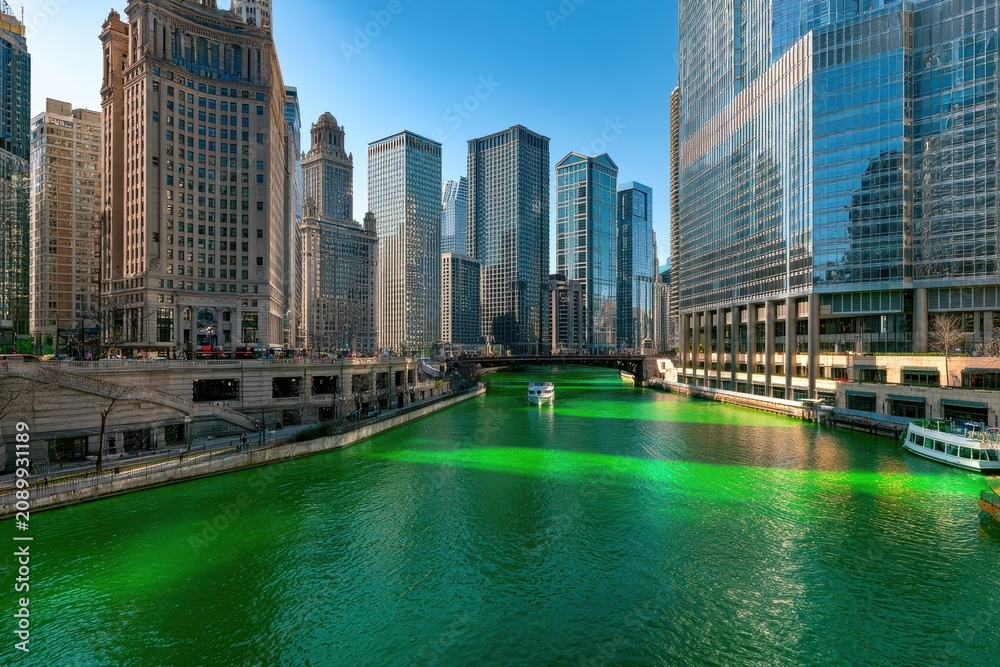 Fototapeta premium City river dyed emerald green beneath a modern and historic skyline