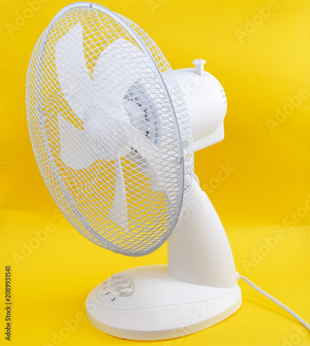 Modern white electric desk fan with speed controls for cooling during summer heat