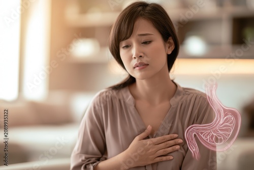 Portrait of an Asian woman experiencing heartburn symptoms in a calm home setting