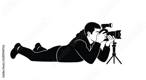 Photos Photographer lying prone with camera and tripod a black silhouette against a whi