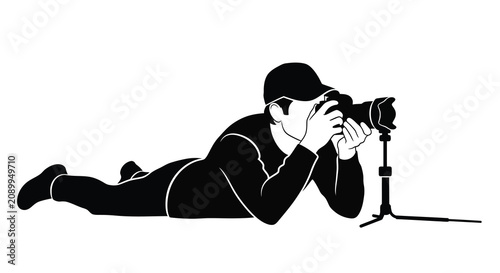 Tableau sur toile Lying photographer with camera on tripod black and white graphic silhouette phot
