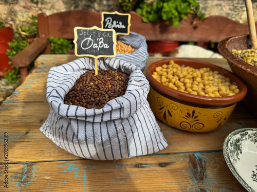 Raw ingredients for Cretan psarokollyva with labels reading split pea (fava) and chickpeas next to the traditional dish.