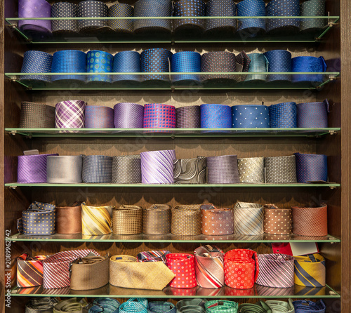 Obraz na płótnie Neatly folded ties of different colors are laid out on a shelf