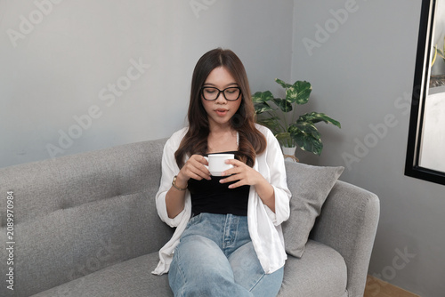 Young Asian Indonesian Woman Relaxing with a Cup of Coffee at Home