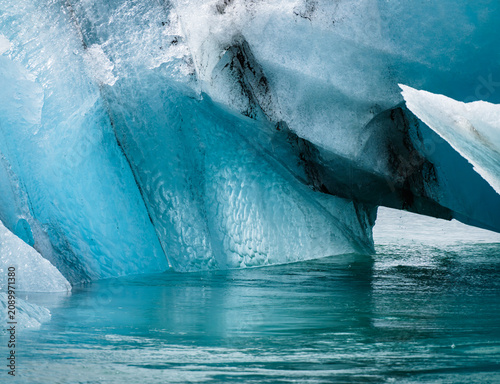 Obraz na plátně Panoramic view of blue ice blocks floating in the water at Jökulsárlón lagoon with glacier in the background