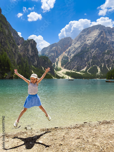 Bild auf Leinwand Happy girl jumping in joy at lake braies