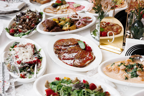 Foto A lavish spread of delicious food dishes artfully arranged on a dining table, sh