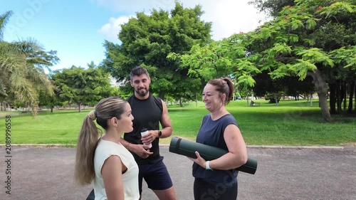 A group of friends chat happily after a training session in the park