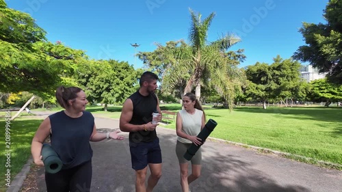 A group of friends are walking through the park after their training session