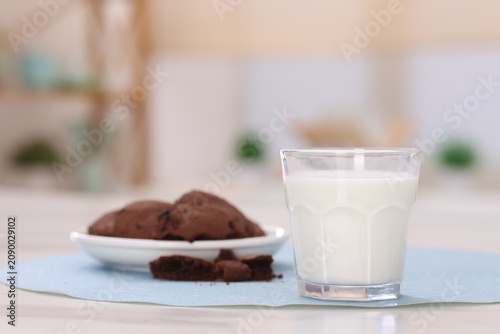 Fotografi Fresh milk in glass and tasty chocolate cookies on light table indoors, closeup