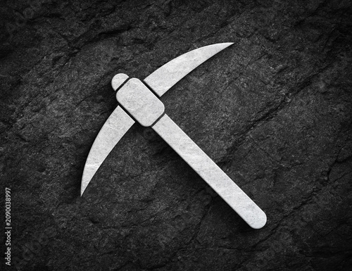 Pickaxe mining tool symbol carved on stone wall
