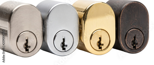 Door lock cylinder metal finishes in brass bronze chrome and nickel hardware options for home security and architectural locksets protection concept close up isolated on black background.