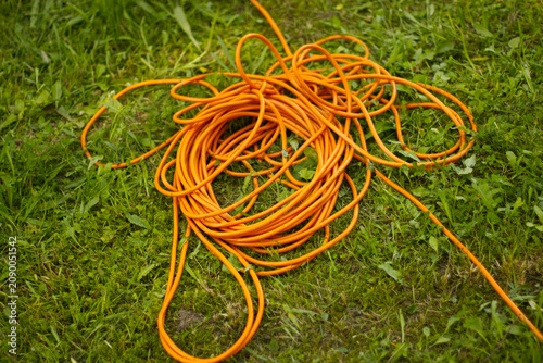 Orange extension cord on green grass