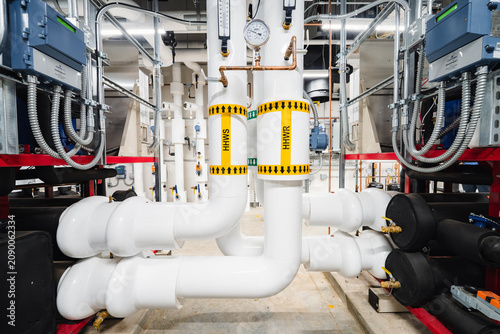 Fotografie Commercial Mechanical Room with Complex White Insulated Piping and HHW Gauges