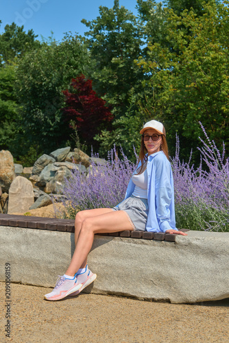A girl walks through a Japanese garden in summer