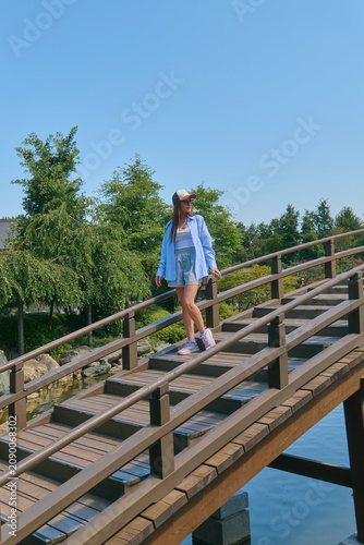 A girl walks through a Japanese garden in summer