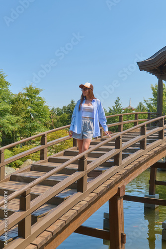 A girl walks through a Japanese garden in summer