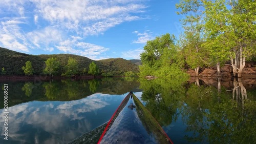 Relaxing POV kayaking through the scenic sandstone canyons of Horsetooth Reservoir in Fort Collins, Colorado. Peaceful summer morning paddle on calm water with the bow of a carbon fiber kayak. 