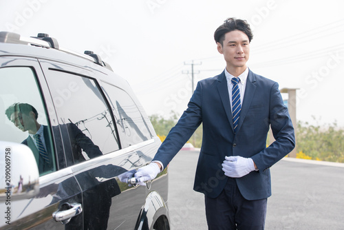 Photography Professional chauffeur opening SUV door for premium transport service