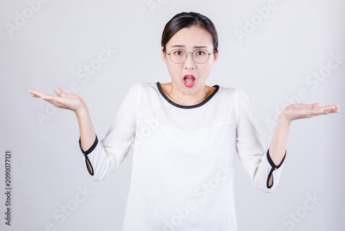 Foto Surprised young woman shrugging with confused expression
