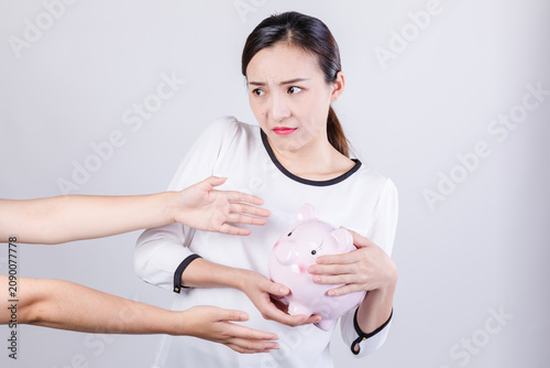 Canvastavla Worried woman protecting piggy bank from reaching hands